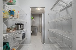 Walk-through pantry featuring extensive wire shelving on both walls, light gray wall paint, and white baseboards - 