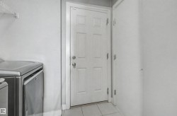 Functional utility space featuring a paneled door, tile flooring, and integrated wire shelving - 