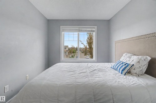 Bright bedroom featuring light gray walls and a single window with white trim - 1602 Chapman Way, Edmonton, AB - Indoor Photo Showing Bedroom