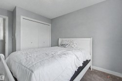 Bedroom featuring light gray walls, gray carpet flooring, and white trim - 