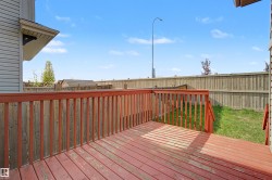 Spacious outdoor deck featuring red-stained wood decking and railings - 
