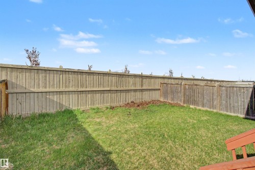 Private backyard featuring a wooden privacy fence, a green lawn, and a small garden bed - 1602 Chapman Way, Edmonton, AB - Outdoor