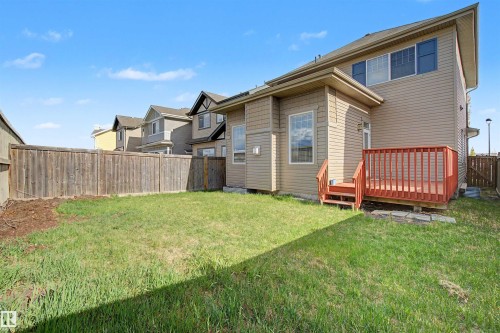Expansive rear yard featuring a wooden privacy fence, a grass lawn, and a multi-level wooden deck with steps - 1602 Chapman Way, Edmonton, AB - Outdoor