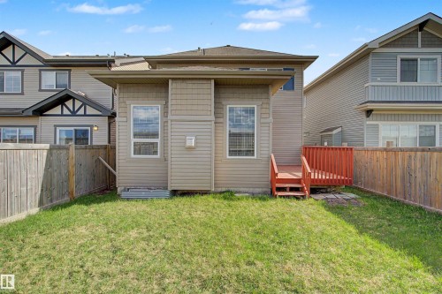 Private fenced backyard featuring a wood deck with railings, natural grass, and a wood privacy fence - 1602 Chapman Way, Edmonton, AB - Outdoor