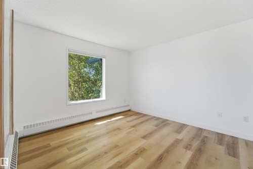 Room featuring light wood-finish flooring, white walls, and a white window frame - 302 2508 50 Street Nw, Edmonton, AB - Indoor Photo Showing Other Room
