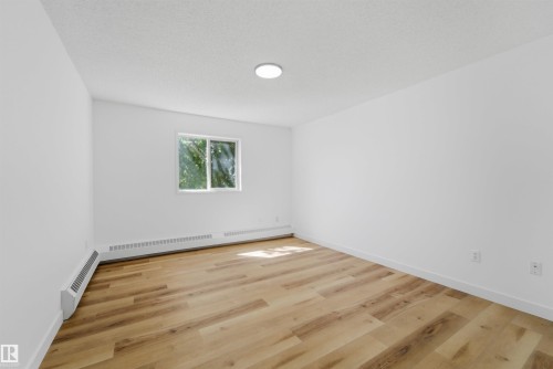 Bright room featuring wood-finish flooring and white baseboards - 302 2508 50 Street Nw, Edmonton, AB - Indoor Photo Showing Other Room