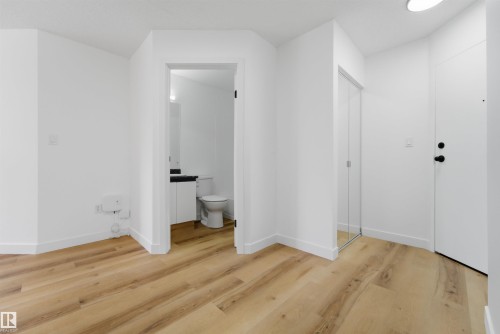 Interior space featuring wood-finish flooring, white walls, and bright overhead lighting - 302 2508 50 Street Nw, Edmonton, AB - Indoor Photo Showing Other Room