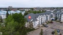 Multi-story residential complex featuring light-colored siding, peaked roofs, and individual balconies - 302 2508 50 Street Nw, Edmonton, AB  - Outdoor 