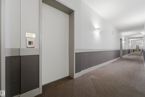 Modern hallway with recessed lighting and sconces illuminating a textured carpet runner - 302 2508 50 Street Nw, Edmonton, AB - Indoor Photo Showing Other Room