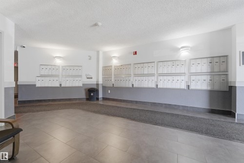 Building lobby featuring individual mailboxes, overhead lighting, and grey tile flooring - 302 2508 50 Street Nw, Edmonton, AB - Indoor