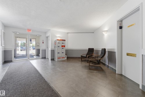 Entryway featuring dual glass doors, large format tile flooring, and a two-tone wall treatment - 302 2508 50 Street Nw, Edmonton, AB - Indoor Photo Showing Other Room