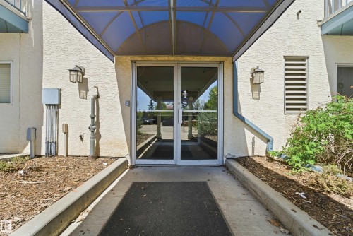 Glass entry doors under a curved translucent awning - 302 2508 50 Street Nw, Edmonton, AB - Outdoor With Exterior
