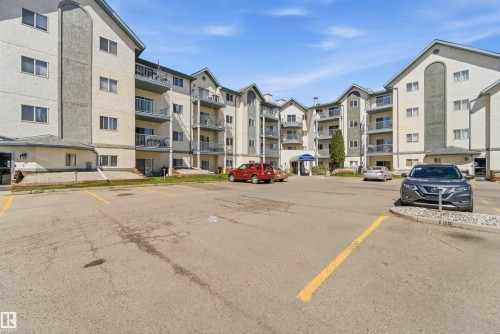 Multi-story residential building featuring light-colored exterior siding with contrasting dark gray accents - 302 2508 50 Street Nw, Edmonton, AB - Outdoor With Facade