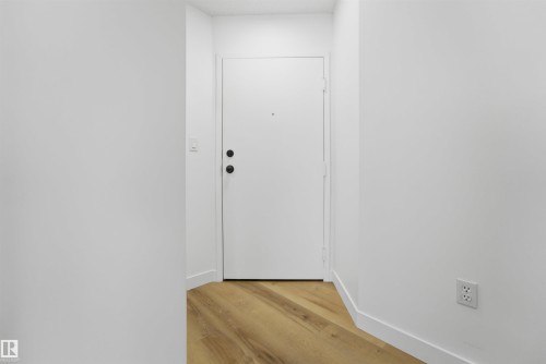 Entryway with wood-finish flooring and crisp white baseboards - 302 2508 50 Street Nw, Edmonton, AB - Indoor Photo Showing Other Room