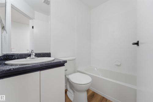 Bathroom featuring a white vanity with a dark patterned countertop, an oval undermount sink, and chrome fixtures - 302 2508 50 Street Nw, Edmonton, AB - Indoor Photo Showing Bathroom