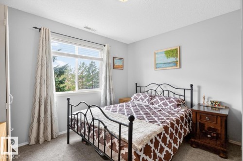Double-paned window with horizontal blinds and drapery rods - 220 16303 95 Street, Edmonton, AB - Indoor Photo Showing Bedroom
