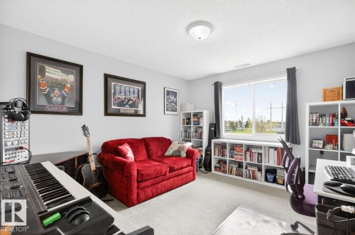 Carpeted room featuring a large window, light gray walls, and white ceiling - 220 16303 95 Street, Edmonton, AB - Indoor