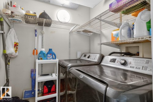 Dedicated laundry area featuring a washer and dryer, along with wall-mounted wire shelving for storage - 220 16303 95 Street, Edmonton, AB - Indoor Photo Showing Laundry Room