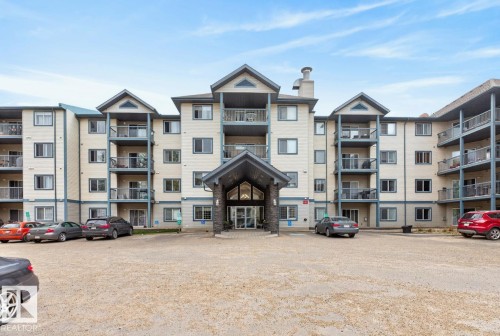Multi-story building featuring a central covered entrance with stone accents - 220 16303 95 Street, Edmonton, AB - Outdoor With Balcony With Facade