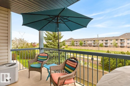 Private balcony featuring a textured concrete surface and metal railings - 220 16303 95 Street, Edmonton, AB - Outdoor With Balcony With Exterior