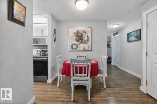 Dining area featuring wood-finish flooring, light grey walls, and a recessed ceiling light - 220 16303 95 Street, Edmonton, AB - Indoor Photo Showing Other Room
