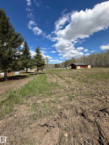 Expansive open field with tilled soil, surrounded by mature evergreen trees and a distant wooded area - #41 59419 Rge Rd 240, Rural Westlock County, AB - Outdoor With View
