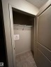 Utility closet featuring a wire shelf and tiled flooring - 205 11445 Ellerslie Road, Edmonton, AB 