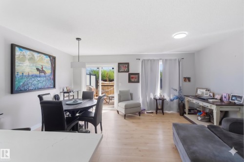 Light wood-finish flooring throughout the open concept living and dining areas - 5129 Lark Crescent, Edmonton, AB - Indoor Photo Showing Other Room