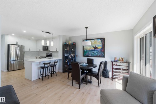 Open-concept living area featuring light wood-finish flooring throughout - 5129 Lark Crescent, Edmonton, AB - Indoor