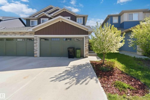 Multi-car attached garage with decorative windows and stone accents - 5129 Lark Crescent, Edmonton, AB - Outdoor