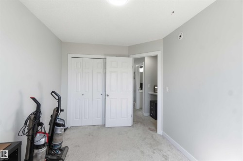 Neutral-toned room featuring a light carpeted floor, white baseboards, and a bi-fold closet with white panel doors - 5129 Lark Crescent, Edmonton, AB - Indoor Photo Showing Other Room