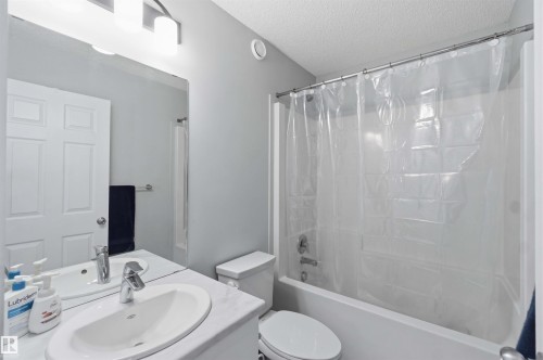 Bathroom featuring a single vanity with an oval basin sink, a wall-mounted mirror, and a combination shower-bathtub with a chrome fixture - 5129 Lark Crescent, Edmonton, AB - Indoor Photo Showing Bathroom
