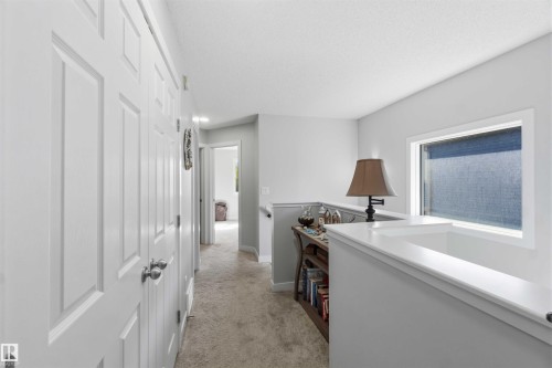 Upper-level hallway with light gray walls, white trim, and carpeted flooring - 5129 Lark Crescent, Edmonton, AB - Indoor