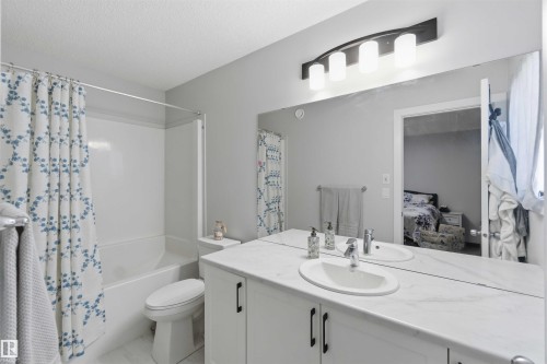 Dual sink vanity with stone-finish countertop - 5129 Lark Crescent, Edmonton, AB - Indoor Photo Showing Bathroom