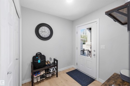 Entryway featuring a white door with a window pane, light wood-finish flooring, and a white bi-fold closet door - 5129 Lark Crescent, Edmonton, AB - Indoor Photo Showing Other Room