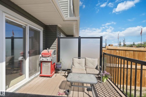 Outdoor deck featuring wood-finish flooring and black metal railings - 5129 Lark Crescent, Edmonton, AB - Outdoor With Exterior