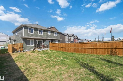 Expansive backyard featuring a partial lawn, full wood fencing, and a multi-level deck with dark railings - 5129 Lark Crescent, Edmonton, AB - Outdoor With Deck Patio Veranda