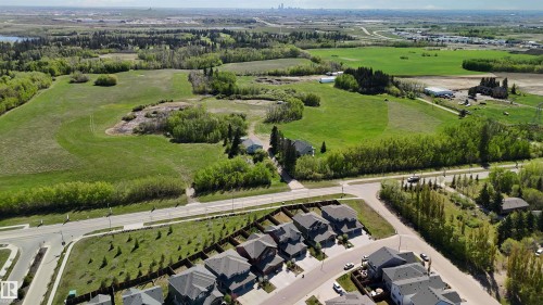 Expansive green fields with clusters of deciduous trees and a distant city skyline - 5129 Lark Crescent, Edmonton, AB - Outdoor With View