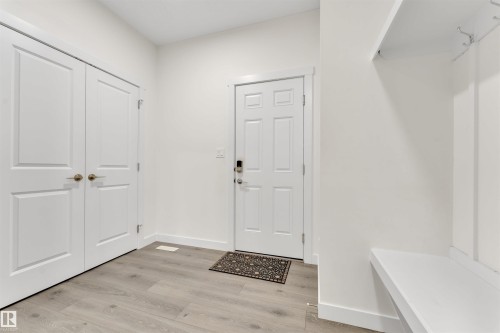 Entryway featuring wood-finish flooring, a built-in storage bench, and a panel door with smart lock - 22534 98A Avenue, Edmonton, AB - Indoor Photo Showing Other Room