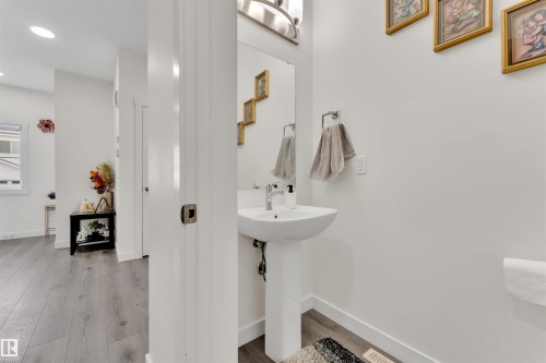 Pedestal sink with chrome faucet and wall-mounted vanity light - 22534 98A Avenue, Edmonton, AB - Indoor Photo Showing Bathroom