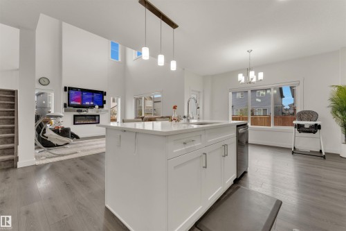 Kitchen island with white cabinetry, a sink with a gooseneck faucet, and pendant lighting overhead - 22534 98A Avenue, Edmonton, AB - Indoor Photo Showing Kitchen