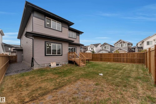 Rear exterior featuring a wooden deck with stairs, a fenced yard, and gravel side access - 22534 98A Avenue, Edmonton, AB - Outdoor