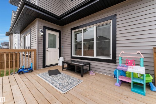 Expansive wood deck with a full wood railing, featuring durable vinyl siding and contrasting black window trim - 22534 98A Avenue, Edmonton, AB - Outdoor With Deck Patio Veranda With Exterior