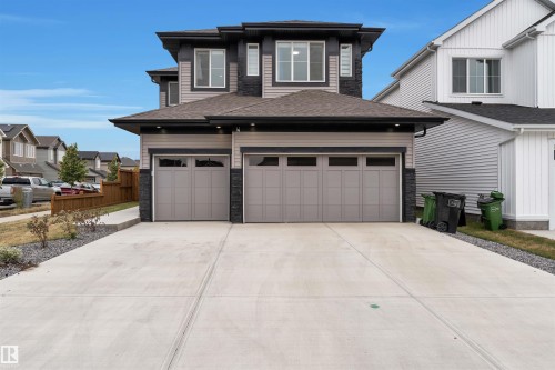 Contemporary exterior featuring mixed material siding, a dual garage with opaque panel doors, and a concrete driveway - 22534 98A Avenue, Edmonton, AB - Outdoor