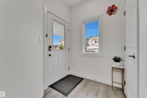 Foyer featuring wood-finish flooring, white paneled interior doors, and crisp white walls - 22534 98A Avenue, Edmonton, AB - Indoor Photo Showing Other Room