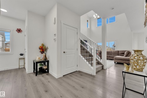 Entryway featuring wood-finish flooring and a staircase with white risers and black metal balusters - 22534 98A Avenue, Edmonton, AB - Indoor