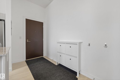 Entryway featuring a dark brown door, light wood-finish flooring, and white walls - 808 2612 109 Street, Edmonton, AB - Indoor Photo Showing Other Room