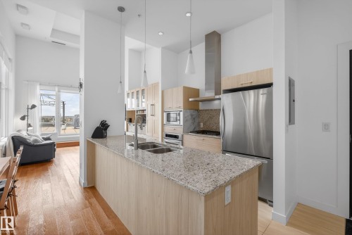 Modern kitchen featuring a large center island with a double sink, stainless steel appliances, light wood-finish cabinetry, and recessed lighting - 808 2612 109 Street, Edmonton, AB - Indoor Photo Showing Kitchen With Double Sink With Upgraded Kitchen