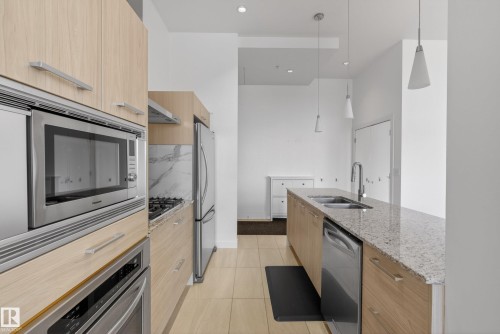Contemporary kitchen featuring light wood-finish cabinetry and stainless steel appliances - 808 2612 109 Street, Edmonton, AB - Indoor Photo Showing Kitchen With Double Sink With Upgraded Kitchen