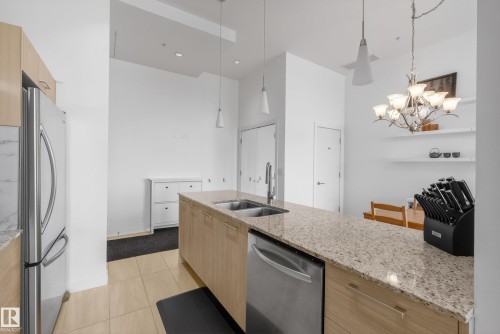 Kitchen island featuring a double-basin sink, light-toned granite countertop, and integrated stainless steel dishwasher - 808 2612 109 Street, Edmonton, AB - Indoor Photo Showing Kitchen With Double Sink With Upgraded Kitchen